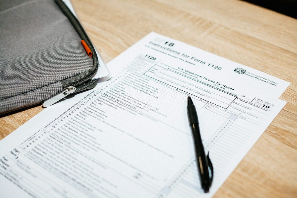 Income tax form 1120 with pen and folder on wooden desk, for corporate return filing and financial documentation strategy