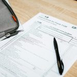 Income tax form 1120 with pen and folder on wooden desk, for corporate return filing and financial documentation strategy