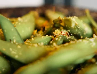 Close-up of seasoned edamame beans sprinkled with sesame seeds, perfect for a healthy snack or appetiser