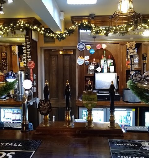 Festive pub interior with beer taps, festive decor, and a warm, inviting atmosphere in a traditional British bar setup