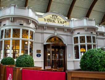 Exterior of York Tap pub with arched windows and decorative glass at York railway station in England