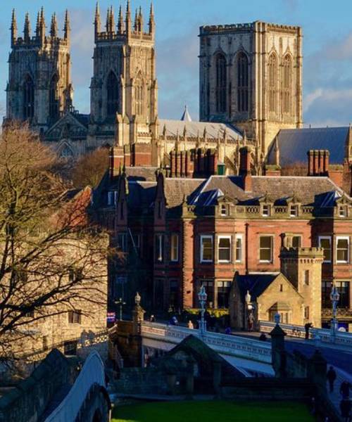 Historic York cityscape with iconic York Minster towers, showcasing medieval architecture and charming streets in sunlight