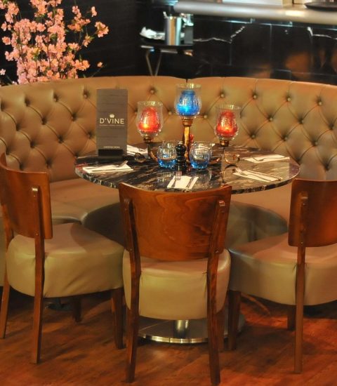 Cosy restaurant seating with round table, elegant decor, and ambient lighting for an intimate dining experience.