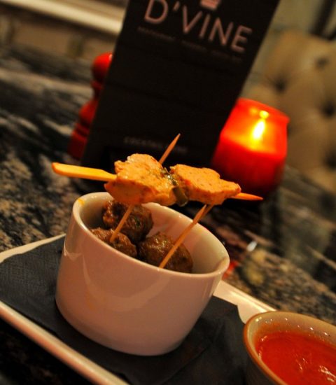Gourmet appetisers served at D'Vine restaurant with a side of dipping sauce on a stylish granite table setting