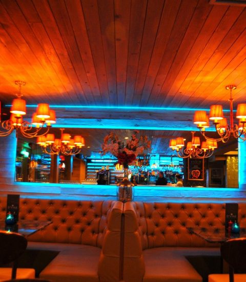 Cosy restaurant interior with warm lighting, elegant chandeliers, and plush seating, creating an inviting dining atmosphere