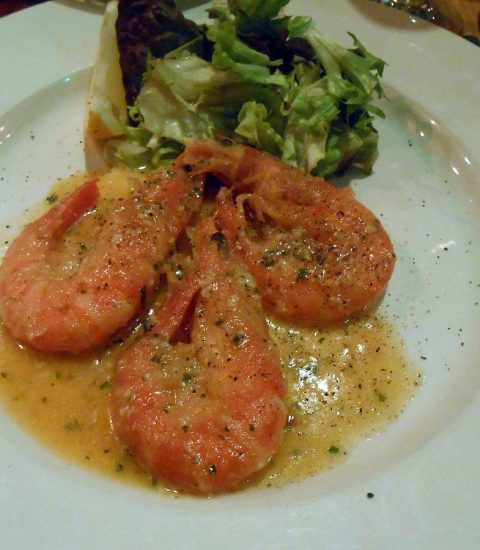 Plate of succulent prawns in garlic butter sauce with fresh salad, perfect seafood dish for a delightful dining experience
