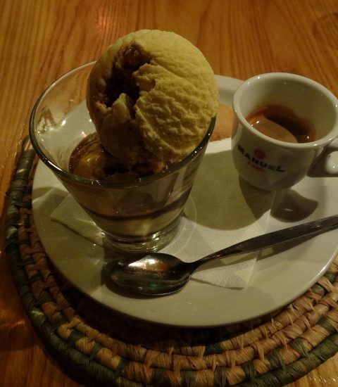 Affogato dessert with ice cream and espresso on a woven mat at a wooden table, perfect for coffee and dessert lovers