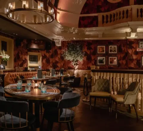 Elegant restaurant interior with dim lighting, plush seating, ornate decor, and framed artwork for a cosy dining experience