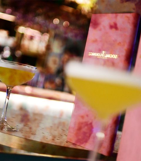 Two elegant cocktails on bar with pink menus at a stylish lounge, creating a chic and inviting atmosphere for relaxation