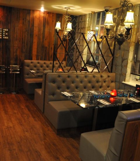Cosy restaurant interior with plush seating, wooden walls, ambient lighting, and elegant decor for a relaxed dining experience